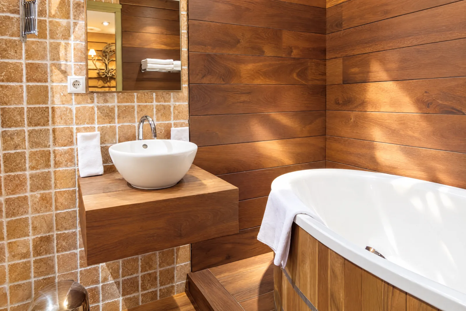 Badkamer met notenhouten wanden, terracotta tegels en een houten ovaal bad