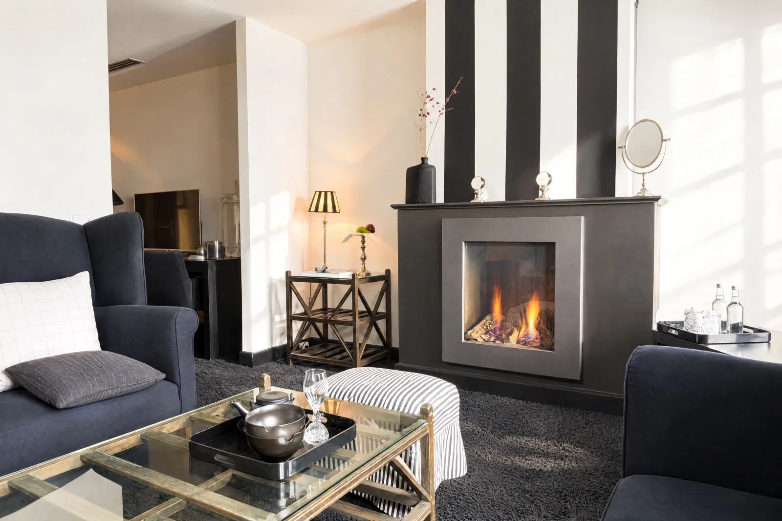 Zithoek met gashaard, zwarte fauteuils en glazen salontafel in de Black & White Suite