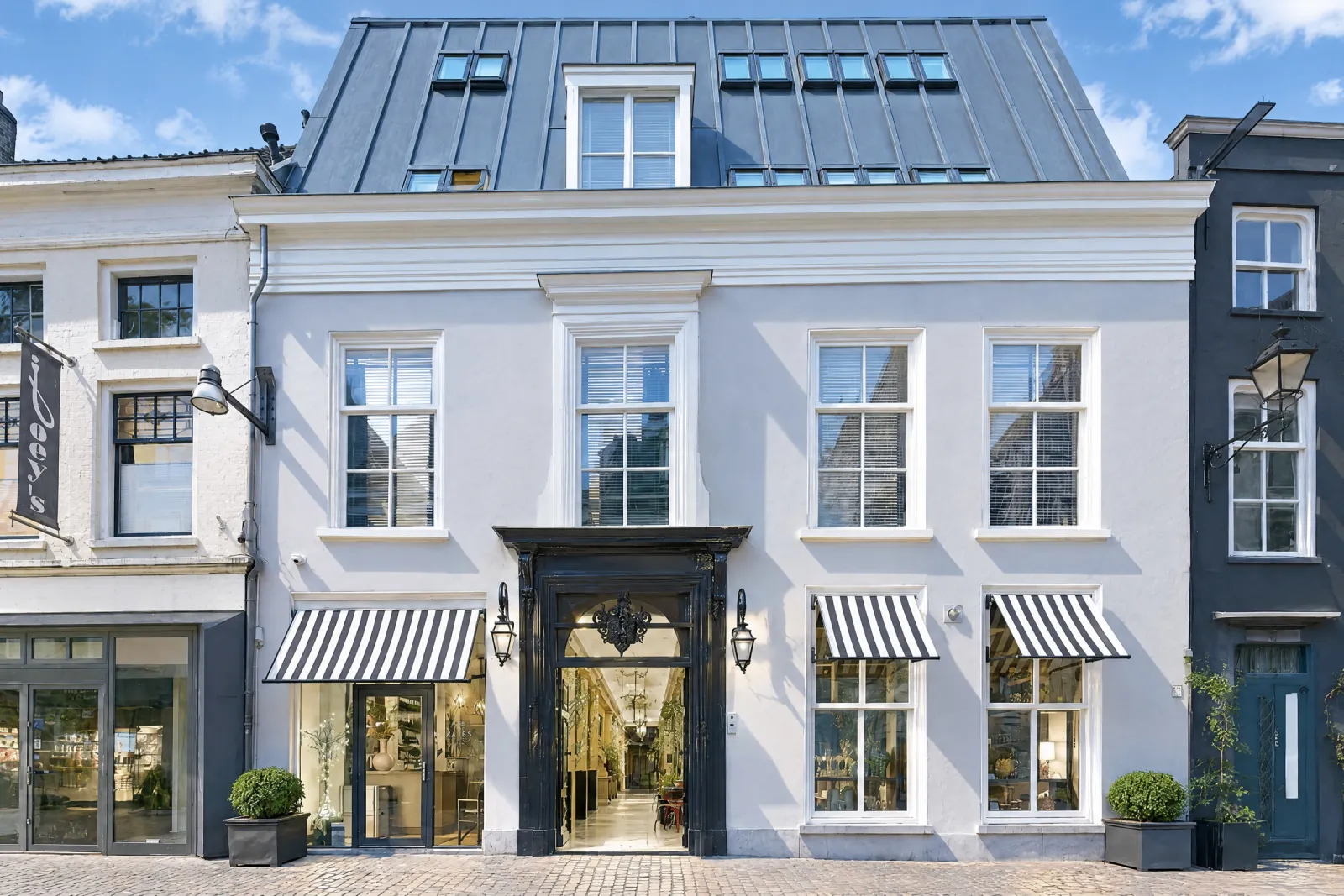 De witte gevel van Bliss aan de Torenstraat op een zonnige dag